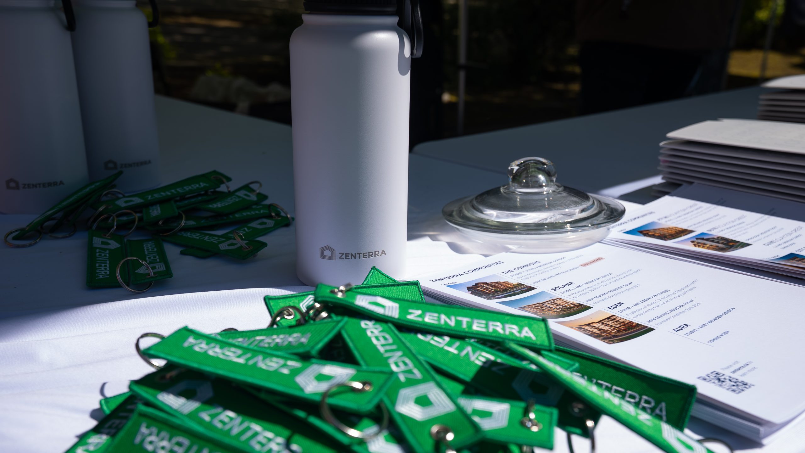Zenterra branded reusable water bottles and green fabric keychains at an Earth Day community booth