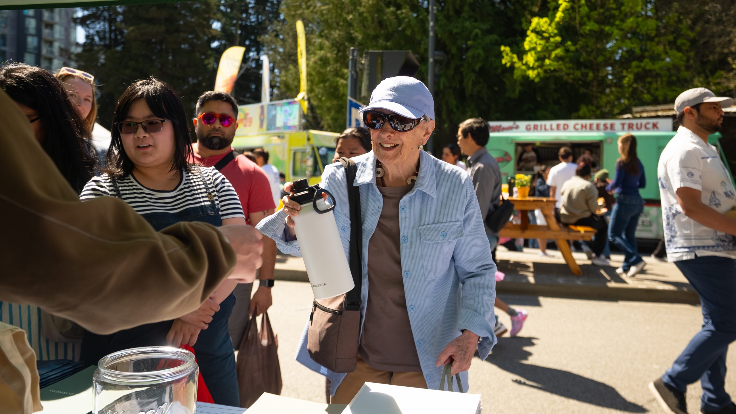 An attendee receiving a Zenterra branded reusable water bottle giveaway at Surrey Party for the Planet