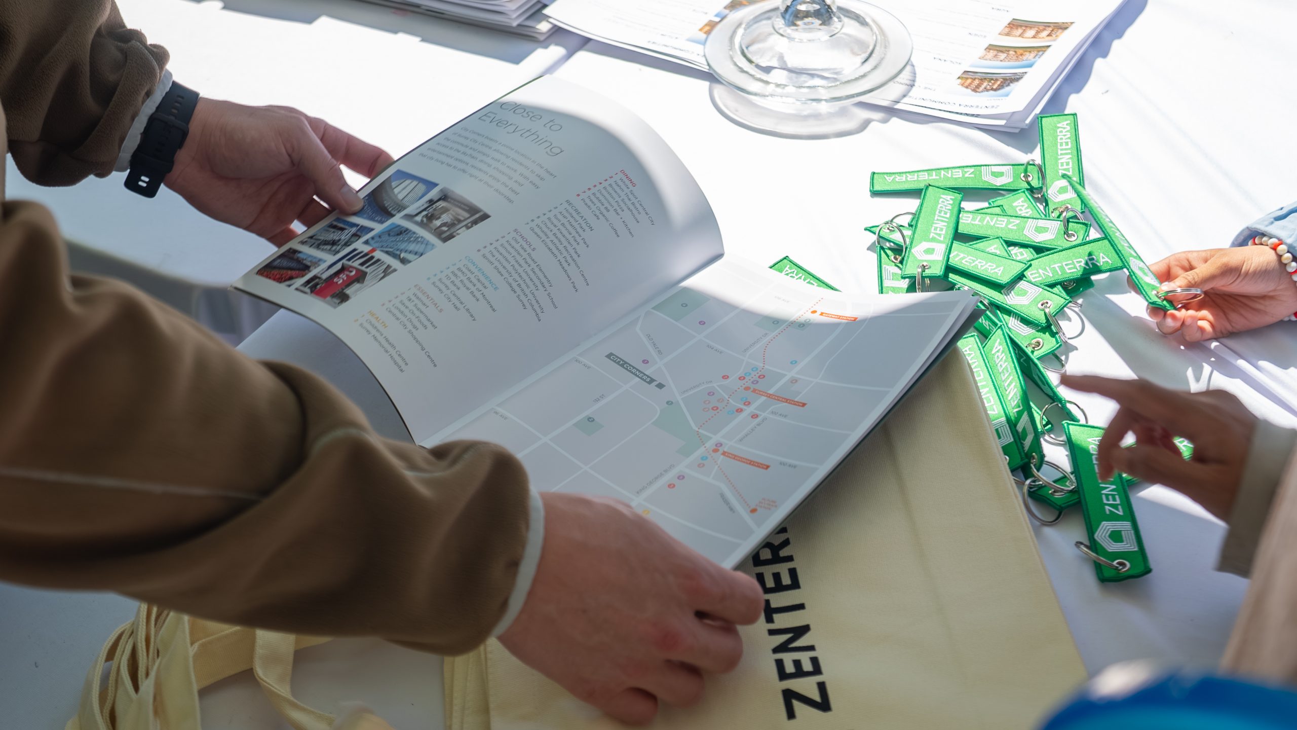 Close up of visitors viewing Zenterra condo community map and brochure at an outdoor event