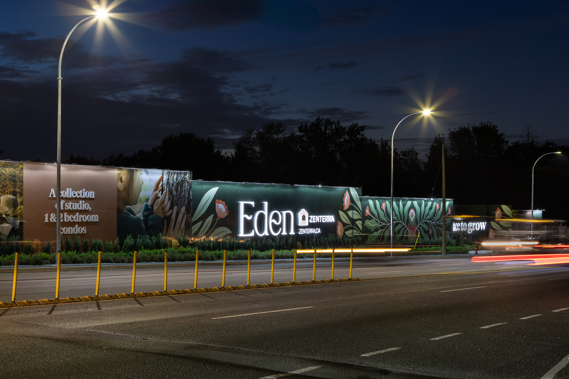 Award winning Eden condo development illuminated construction hoarding signage at night in Langley